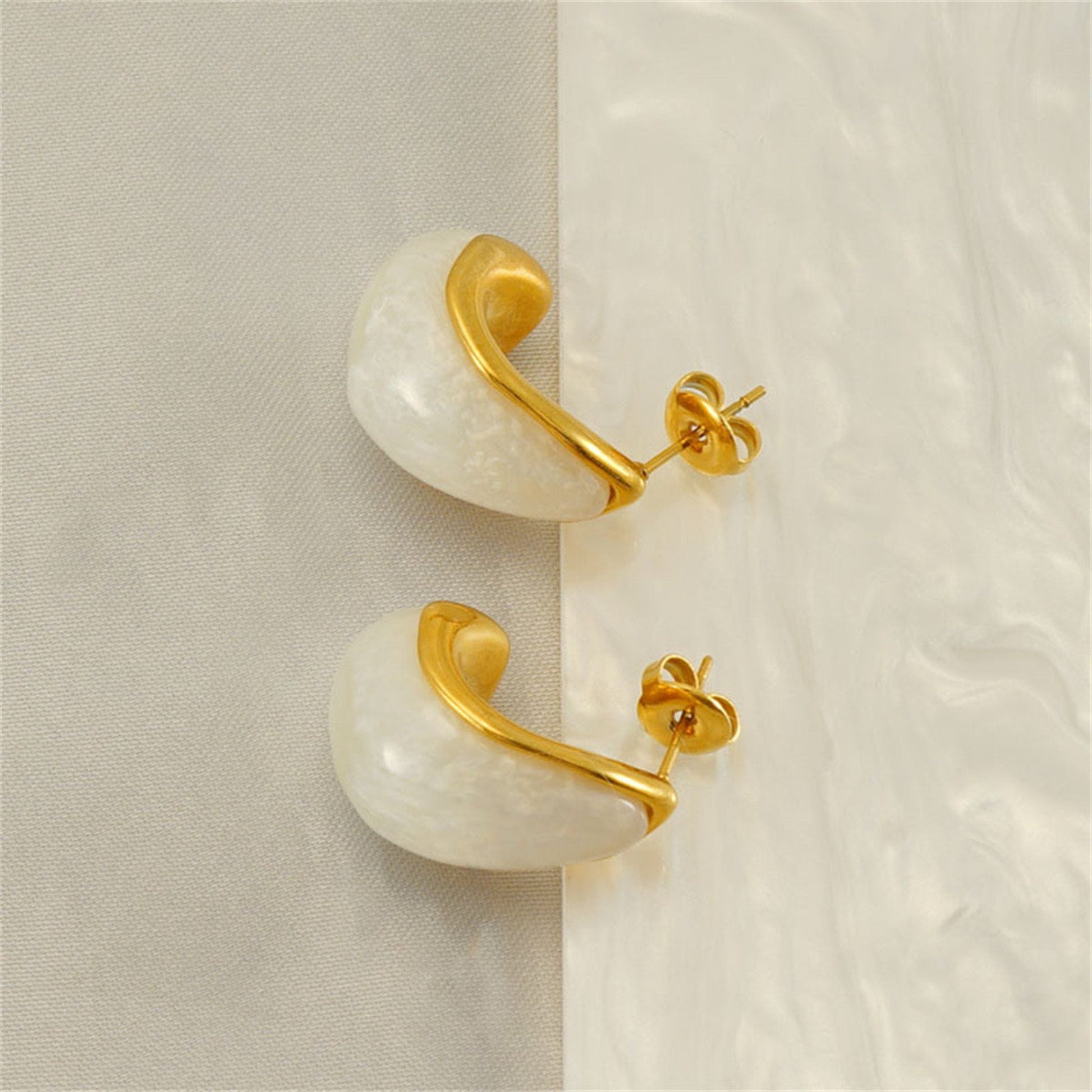 Close-up image of minimalist stud earrings with a sparkling gemstone, ideal for timeless and elegant everyday wear.