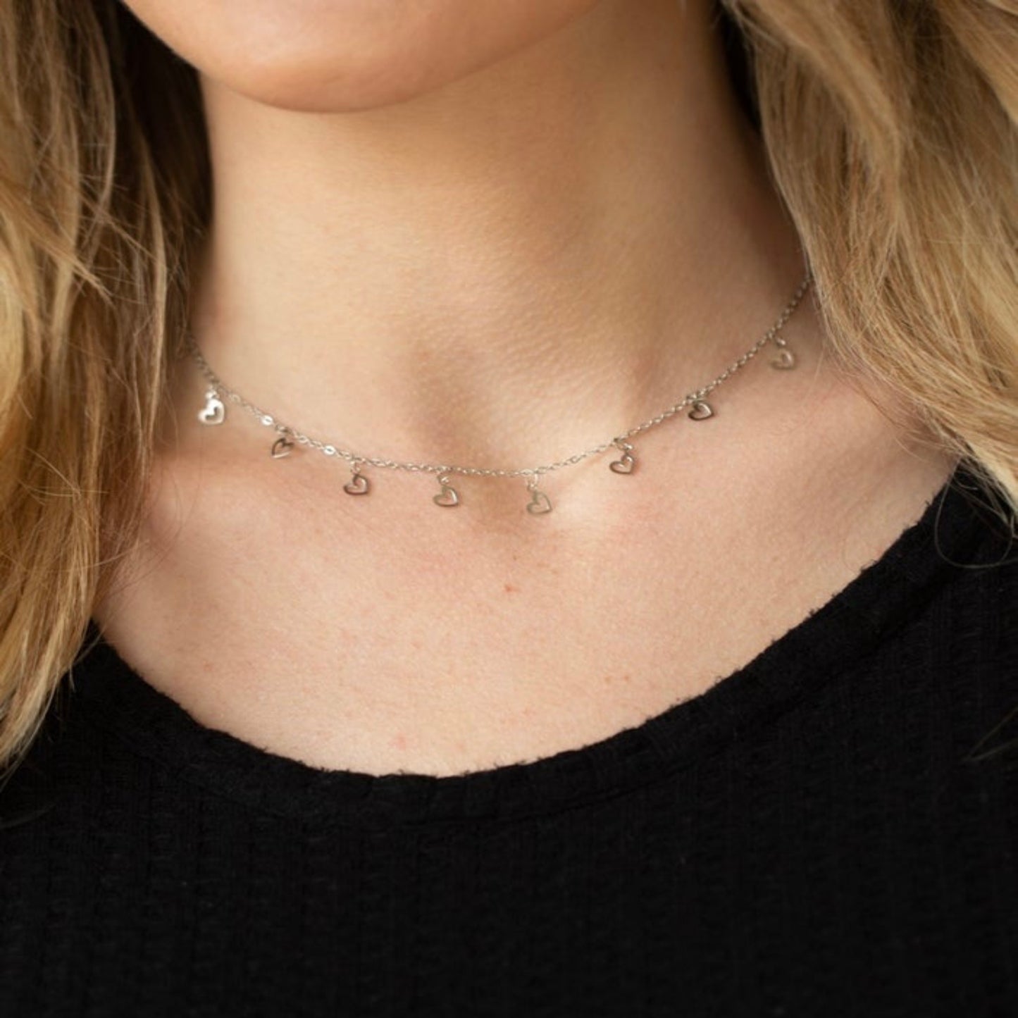 Close-up image of a sleek black velvet choker necklace with a small pendant, ideal for trendy and versatile styling.

