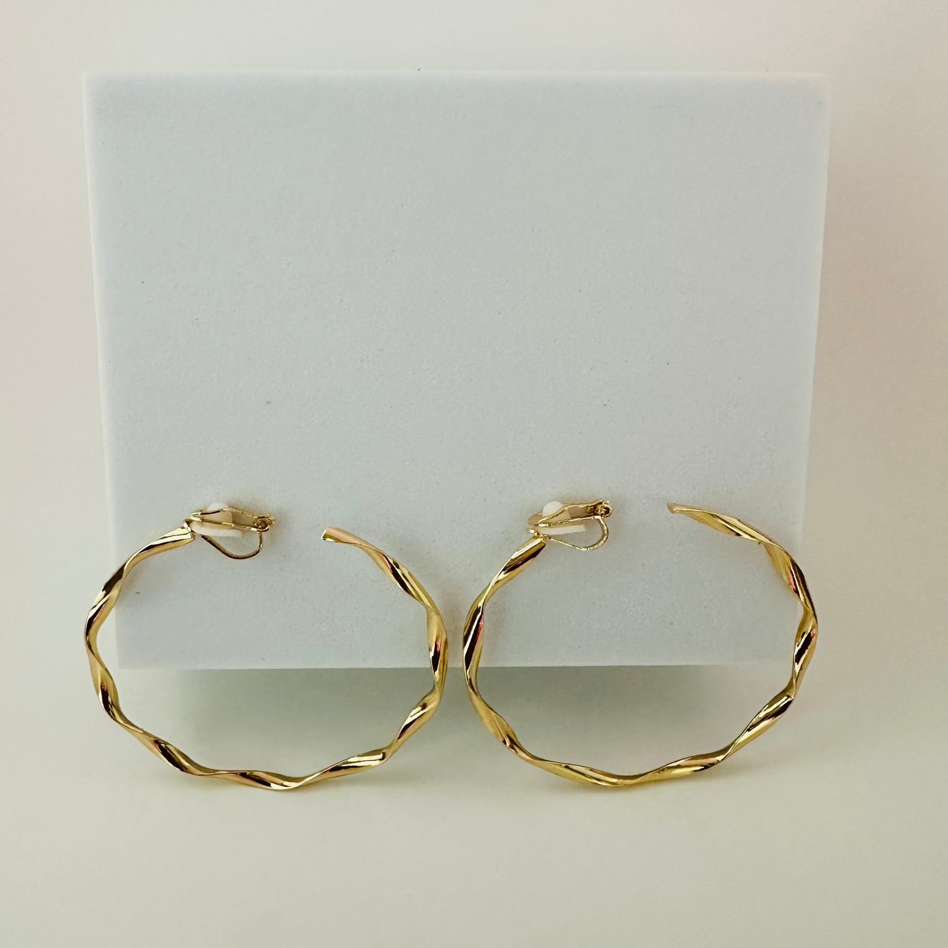 Close-up of sleek gold clip-on hoop earrings, featuring a timeless and comfortable design for non-pierced ears.

Let me know if there’s anything else you’d like to refine!






