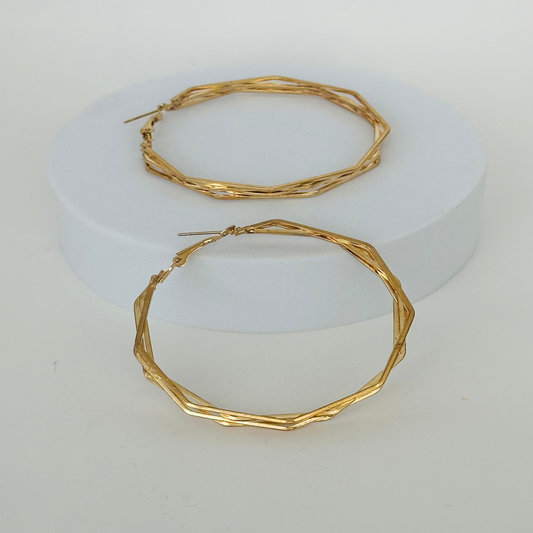 Close-up of elegant gold hoop earrings with a sleek, minimalist design, perfect for casual or formal wear.