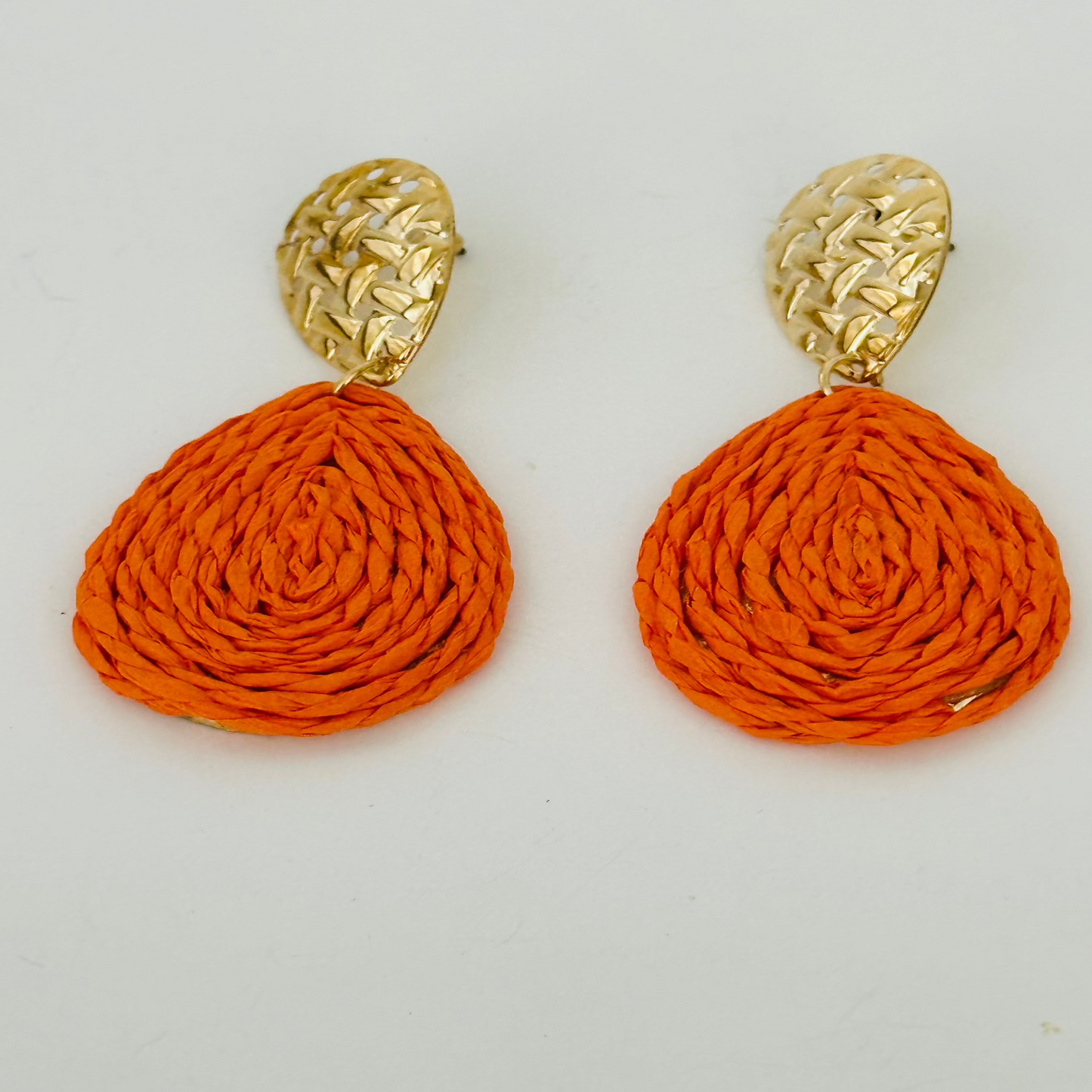 Close-up image of handmade raffia earrings with natural woven textures and vibrant colors, ideal for boho-chic outfits.

