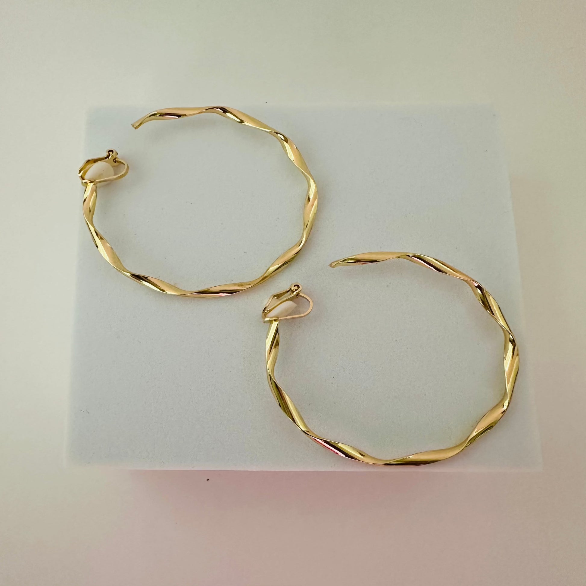 Close-up of sleek gold clip-on hoop earrings, featuring a timeless and comfortable design for non-pierced ears.

Let me know if there’s anything else you’d like to refine!






